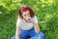 Happy girl smiling outdoor having lunch break. Beautiful young brunete woman with take away coffee cup resting on park or garden Royalty Free Stock Photo