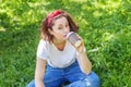 Happy girl smiling outdoor having lunch break. Beautiful young brunete woman with take away coffee cup resting on park or garden Royalty Free Stock Photo