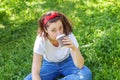 Happy girl smiling outdoor having lunch break. Beautiful young brunete woman with take away coffee cup resting on park Royalty Free Stock Photo