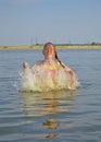 Happy girl splashing merrily in the water, the child jumps out of the water splashes drops around him Royalty Free Stock Photo