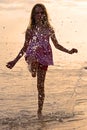 Happy girl splashing water during summer holidays