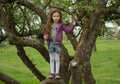 Happy girl standing on branch huge tree