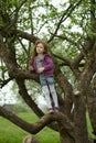 Happy girl standing on branch huge tree