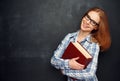 Happy girl student with glasses and book from blackboard Royalty Free Stock Photo