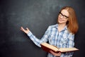 Happy girl student with glasses and book from blank blackboard Royalty Free Stock Photo