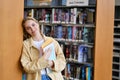Happy girl student holding notebooks standing in college library, portrait. Royalty Free Stock Photo