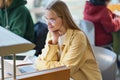 Happy girl student looking at laptop sitting at desk in university campus. Royalty Free Stock Photo