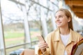 Happy girl student using mobile phone looking away walking indoors. Copy space Royalty Free Stock Photo