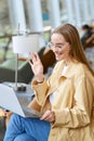 Happy girl student waving hand looking at laptop hybrid learning. Vertical Royalty Free Stock Photo