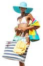 Happy girl in summer beach holiday wearing a bikini and blue sun hat holding beach bag and colorful towel, isolated on white Royalty Free Stock Photo