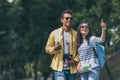 Girl in sunglasses pointing with finger near mixed race man with digital camera Royalty Free Stock Photo