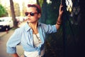 Happy girl with sunglasses on the urban background. Young fancy, funky active people. Outdoors portrait