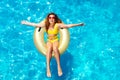 Happy girl swim in pool on inflatable doughnut