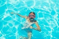 Happy girl in swimming goggles, dives under water with fun in the pool, water sports, snorkeling, family swimming lessons on Royalty Free Stock Photo