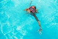 Happy girl in swimming goggles, dives under water with fun in the pool, water sports, snorkeling, family swimming lessons on Royalty Free Stock Photo