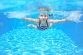 Happy girl swims in pool underwater, active kid swimming and having fun Royalty Free Stock Photo