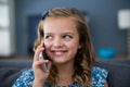 Happy girl talking on mobile phone in living room Royalty Free Stock Photo