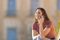 Happy girl talking on mobile phone sitting outdoors Royalty Free Stock Photo
