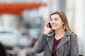 Happy girl talking on mobile phone walking in the street Royalty Free Stock Photo