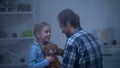 Happy girl with teddy looking with love at dad, trustful relations, tenderness Royalty Free Stock Photo