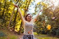 Happy girl throwing leaves walking in fall park. Young woman enjoying autumn having fun outdoors Royalty Free Stock Photo