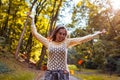 Happy girl throwing leaves walking in fall park. Young woman enjoying autumn having fun outdoors Royalty Free Stock Photo