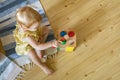 Happy girl toddler hitting wooden hammer on colored balls early development ecological toy Royalty Free Stock Photo