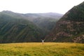 Happy girl - tourist having opened hands on a background of mountains