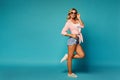 Happy girl in trendy denim shorts, shirt and white sneakers Royalty Free Stock Photo