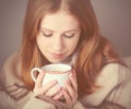 Happy girl is under a blanket and cup of coffee on winter morning at home Royalty Free Stock Photo