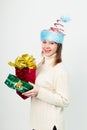 Happy girl in an unusual Christmas hat with gift boxes