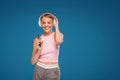 Happy girl using mobile phone listening music with headphones and singing a song loud. Photo of fashionable woman with beautiful Royalty Free Stock Photo