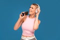 Happy girl using mobile phone listening music with headphones and singing a song loud. Real people emotions. Hobby concept Royalty Free Stock Photo