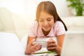 Happy girl using a mobile phone lying on the bed Royalty Free Stock Photo