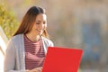 Happy girl using a red laptop outdoors Royalty Free Stock Photo