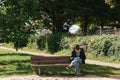 Happy girl using a smart phone in street sitting on a bench. Beautiful girl sitting on a bench, fashion life style with