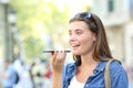 Girl using voice recognition of the phone in the street