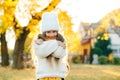 Happy girl walking in autumn park. Little girl wearing warm knitted sweater