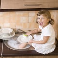 Happy girl washing dishes