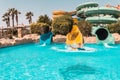 Happy girl on a water slide in the pool, having fun during summer vacation in a beautiful water park Royalty Free Stock Photo