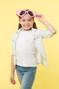 Happy girl wear heart shaped glasses on yellow background. Little child smile in fashion accessory. Funky style beauty Royalty Free Stock Photo