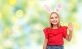 Happy girl wearing easter bunny ears waving hand Royalty Free Stock Photo