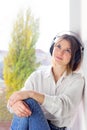 Happy girl wearing headphones. Relaxed young woman enjoying calm music in wireless earphones at home Royalty Free Stock Photo