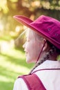 Happy girl wearing school uniform, white shirt, maroon backpack and a hat Back to school. Return to classrooms after COVID-19