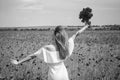 Happy girl in white dress on field of poppies at summer sunset, vacation time Royalty Free Stock Photo