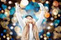 Happy girl in winter earmuffs over holidays lights Royalty Free Stock Photo