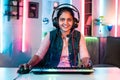 happy girl woman playing video game by talking on headphones while looking camera on neon background - concept of Royalty Free Stock Photo