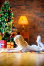 Happy girl writing a letter santa lying on the floor