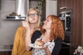 Happy girlfriends eating cake in the kitchen Royalty Free Stock Photo