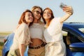 Happy girlfriends taking selfie by car in countryside Royalty Free Stock Photo